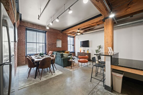 A modern interior with a dining area, seating, and a kitchen counter.