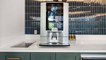 A modern kitchen with a built-in coffee machine, a window with a view, and a countertop with a sink.