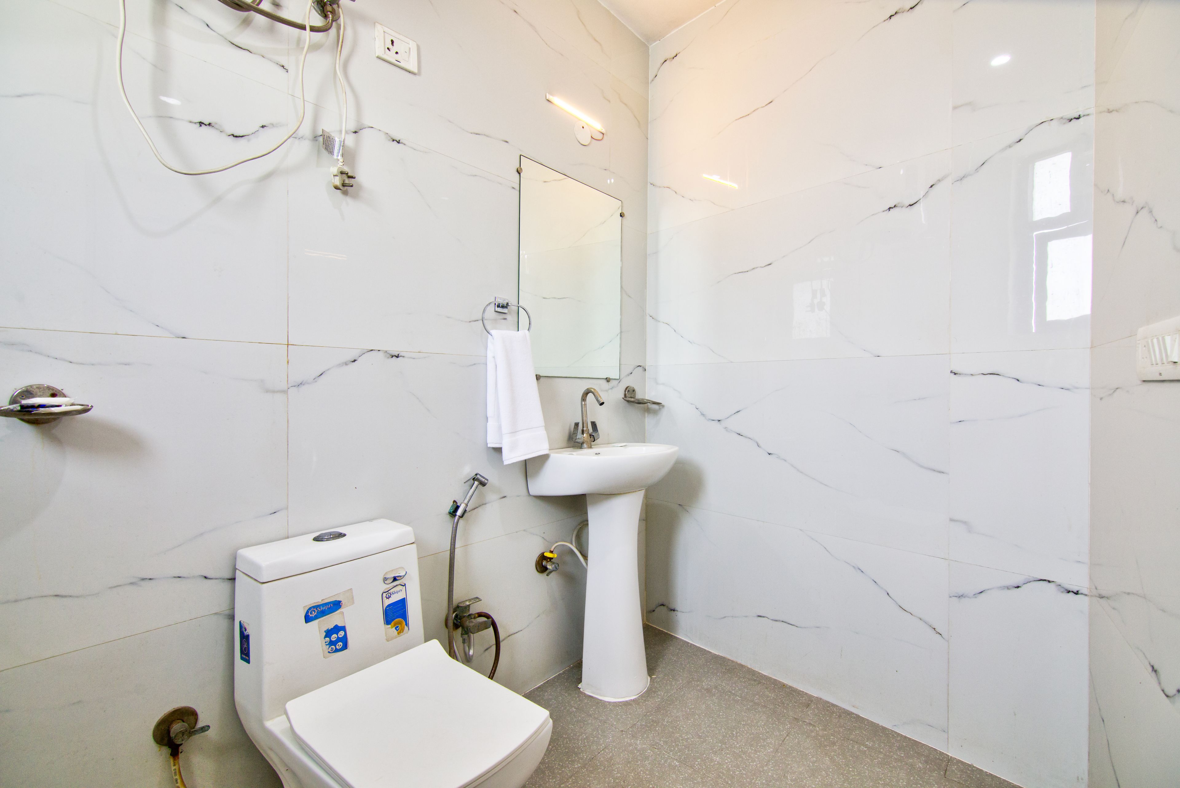 Une salle de bain avec des toilettes, un lavabo et un miroir.