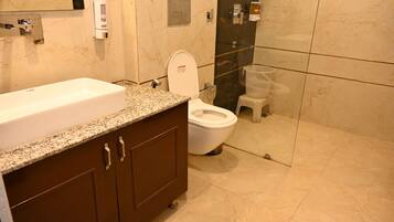 A bathroom with a white sink, a toilet, and a shower area.