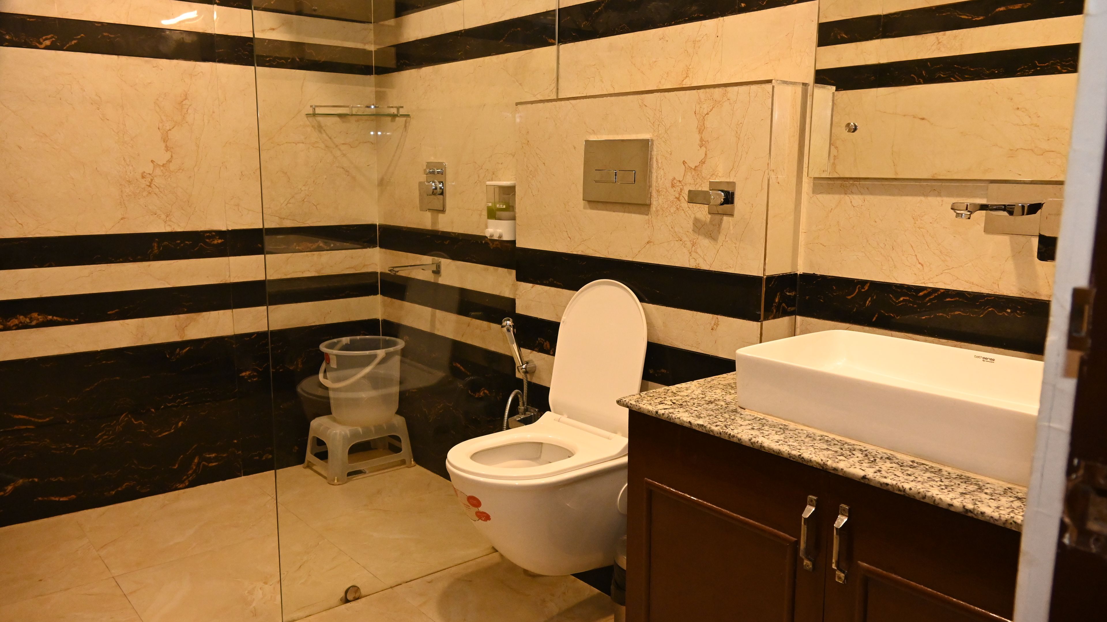 A bathroom with a toilet, bidet, and a sink with a marble countertop.