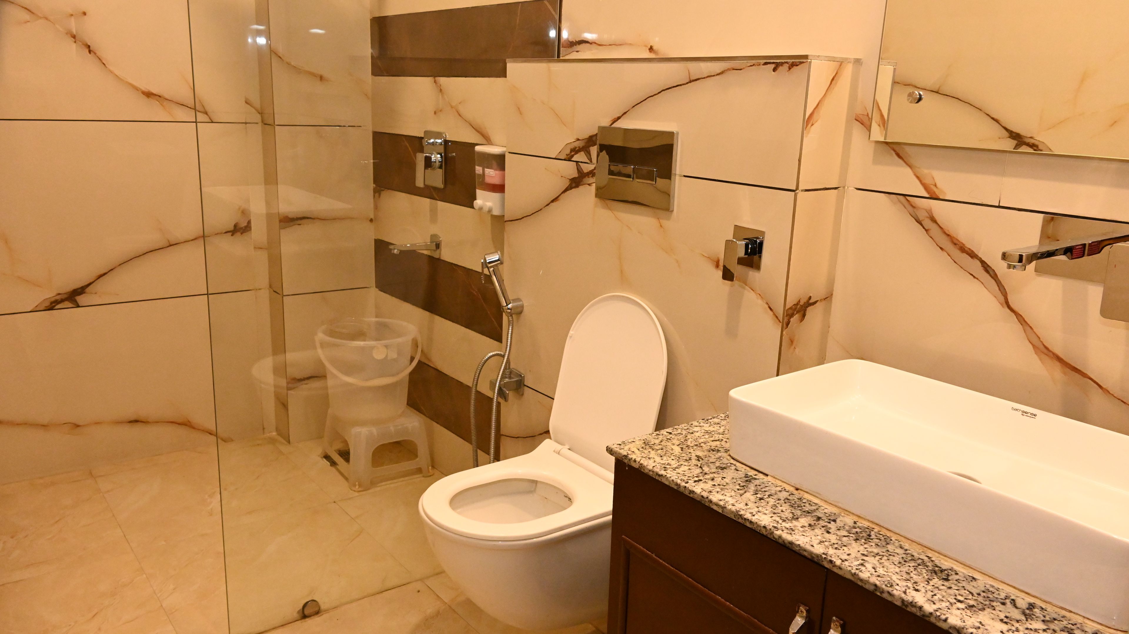 A bathroom with a toilet, shower, and sink.