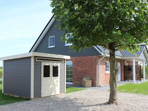 A house with a grey exterior, a brick section, and a tree in front. - Holiday Home in Pommerby With Swimming Pool (Pommerby)