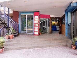A hotel entrance with a staircase, a red vertical sign, and potted plants. - Super Collection O Hubli City Center (Hubli)