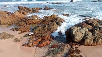 A rocky shoreline with waves crashing against the rocks.