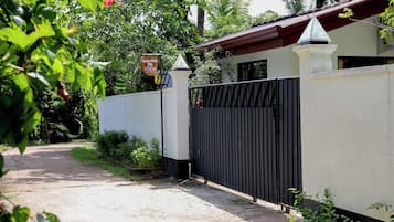 Uma entrada com portão para uma propriedade, com uma placa indicando ser uma Nature Beat Villa.