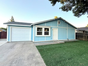 A single-story house with a garage, a front door, and a small porch.