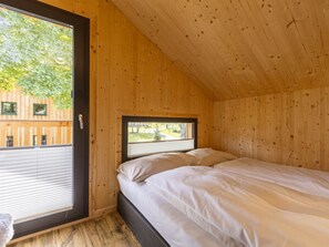 A room with a bed, a window, and a view of the outside. - Cabin With 1 Bedroom (Sankt Georgen am Kreischberg)