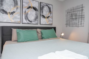 A bedroom with a bed, two pillows, and three abstract paintings on the wall. - Prime Location Near Disney at Bella Vida Resort (Kissimmee)