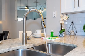 A kitchen with a stainless steel sink, a faucet, and a countertop. - Prime Location Near Disney at Bella Vida Resort (Kissimmee)