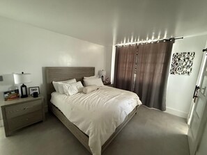 A bedroom with a bed, bedside tables, a nightstand, a lamp, a picture frame, and a curtain. - Cozy 1-bedroom apartment in wonderful Miami Beach with AC (Miami Beach)