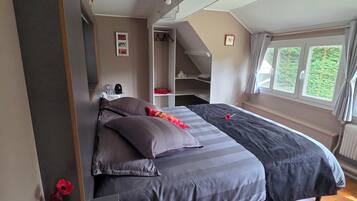Une chambre à coucher avec un lit, une table de chevet, une armoire et une fenêtre.