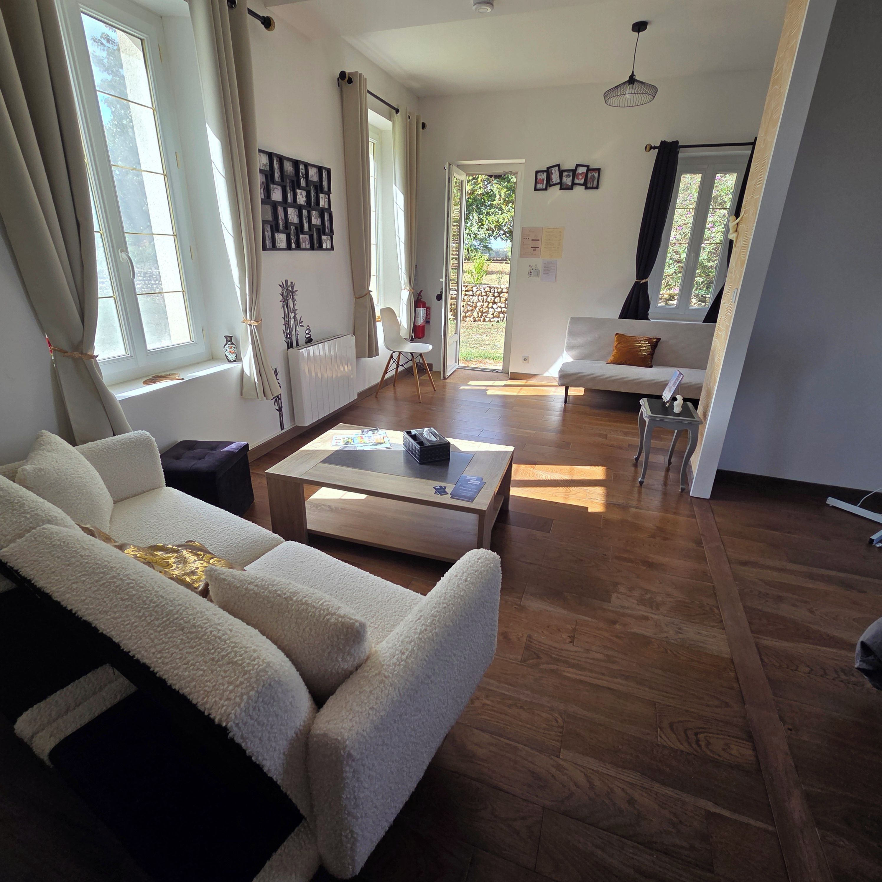 Een ruime woonkamer met een bank, salontafel en uitzicht op het groen.
