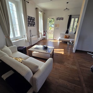 A spacious living area with a sofa, coffee table, and a view of the outdoors.