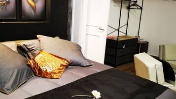 A bedroom with a bed, a dresser, a chair, and a door leading to another room.