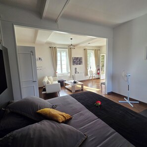 A modern living room with a sofa, a coffee table, and a dining area with a table and chairs.