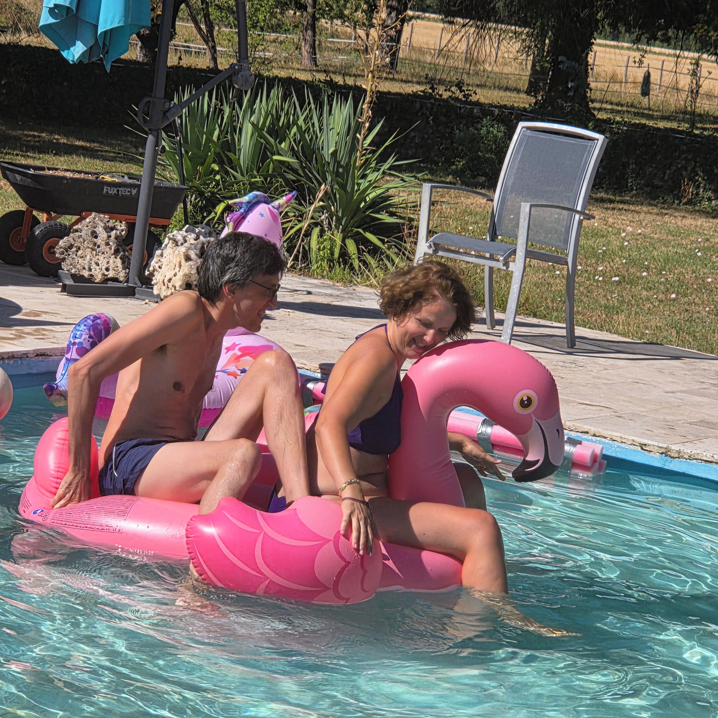 Una piscina con juguetes inflables y una silla.