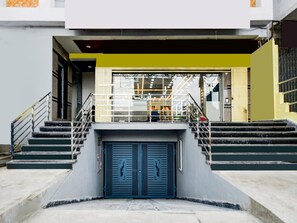 A building entrance with a double door, a staircase, and a railing. - Super Townhouse Badangpet Crossway Hyderabad (Hyderabad)