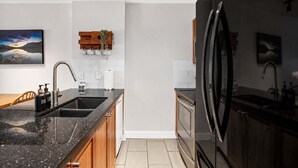Una cocina moderna con encimera de granito, electrodomésticos de acero inoxidable y armarios de madera.