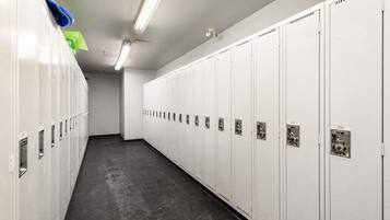 A clean, well-lit locker room with rows of lockers, some with numbers visible.