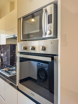 Eine Küche mit Einbau-Mikrowelle, Backofen und Gasherd.