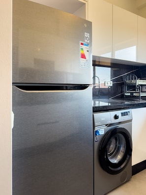 A stainless steel refrigerator with a built-in washing machine below it. - Family-Friendly Home in Marrakech - Air Conditioning - Fiber Optics - 5 min from the Airport - IPTV (Marrakech)