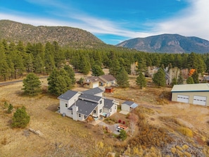 A residential area with multiple houses, a garage, and a mountainous backdrop. - Wolfmoor spacious cabin with trail access (Flagstaff)