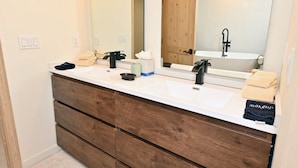 A bathroom with two sinks, a mirror, wooden cabinets, and a bathtub. - 2 Bedroom Peaks Penthouse with stunning views, ski-in/ski-out, pools/spa/golf (Telluride)