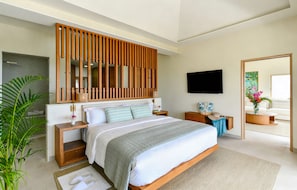 Un dormitorio moderno con una cama grande, cabecera de madera, mesitas de noche, un televisor de pantalla plana y un espejo amplio.