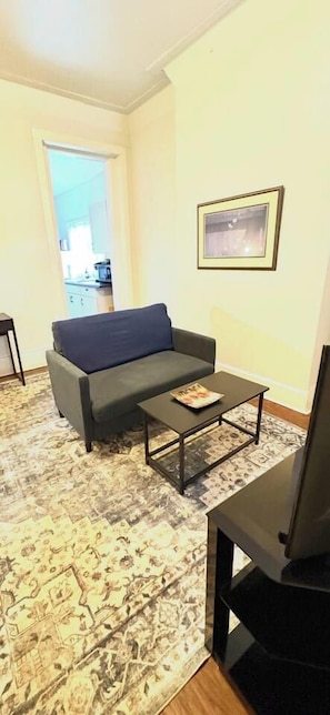 Sala de estar com sofá, mesa de centro e televisão.