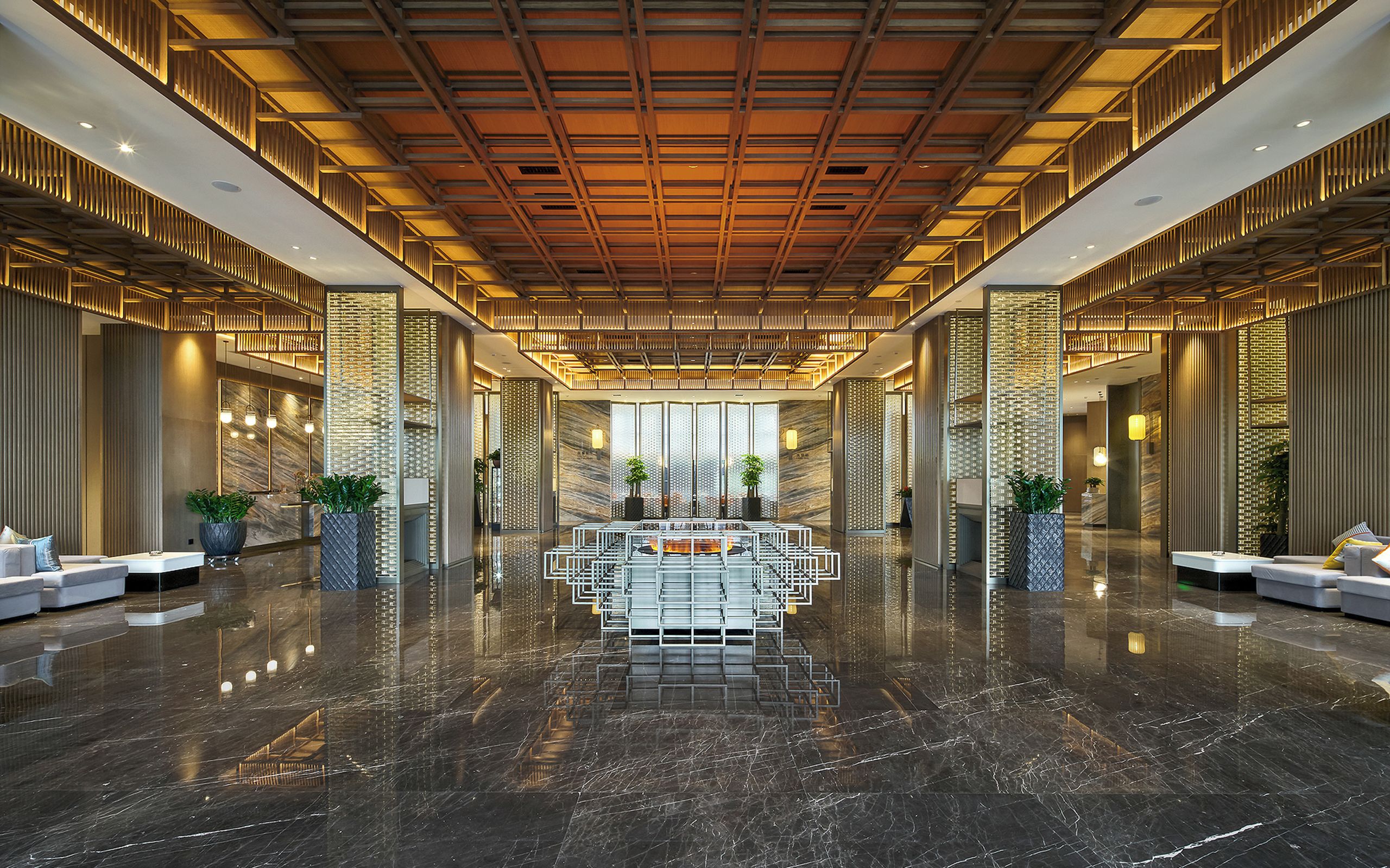 A spacious lobby with a polished marble floor, a central seating area, and modern furnishings.