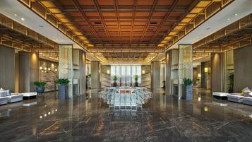 A spacious lobby with a polished marble floor, a central seating area, and modern furnishings.