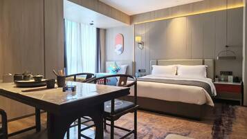 Une chambre d’hôtel comprenant un lit, une table de chevet et un coin repas avec des chaises et une table.