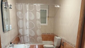 Un bagno con lavabo a piedistallo, water e doccia.