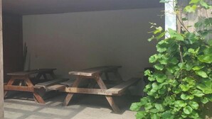 A brick building with a white door and windows, a wooden bench, and a wall-mounted light fixture. - Holiday Apartment in Eggstedt With Terrace (Eggstedt)