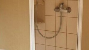 A shower enclosure with a glass door, a handheld showerhead, and a wall-mounted faucet. - Holiday Apartment in Eggstedt With Terrace (Eggstedt)