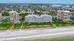 Un paysage urbain côtier avec de grands hôtels, une plage et un port de plaisance.