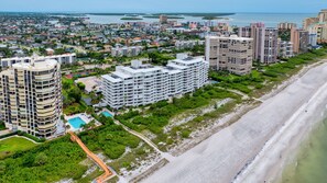 A coastal cityscape with high-rise buildings, a beach, and a swimming pool complex. - Beachfront Condo on Marco Island. Resort style amenities..3 bed, two full bath! (Marco Island)