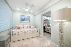 A bedroom with a bed, a ceiling fan, a framed picture on the wall, and a lamp. - Beachfront Condo on Marco Island. Resort style amenities..3 bed, two full bath! (Marco Island)