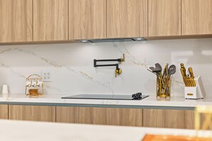 A modern kitchen with wooden cabinets, a marble backsplash, and a glass countertop. - Modern Waterfront Retreat Oversize outdoor Tiki, kitchen and heated SPA (Fort Lauderdale)