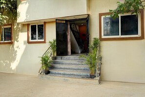 A building entrance with a set of stairs leading to a door, flanked by potted plants. - Super Collection O Kammasandra Gate (Bengaluru)