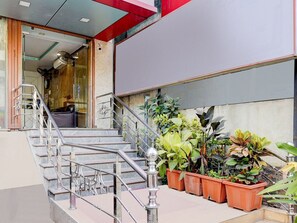 A staircase with metal railings, potted plants, and a view of the interior. - Super Hotel O Porur Jeya's Elite (Chennai)