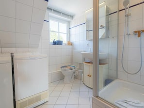 A bathroom with a toilet, a shower, and a radiator. - Holiday Apartment 4 "muller" (St. Peter-Ording)