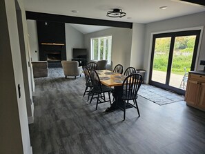 Un espace de salle à manger moderne, doté d’une grande table, de chaises et d’une cheminée.