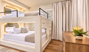 Habitación con literas, mesita de noche y cortinas.