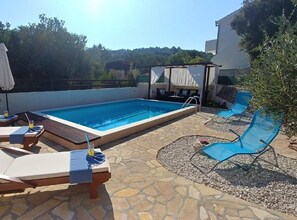 A rooftop pool area with lounge chairs and a covered seating area. - Three Bedroom Apartment with Balcony (Rogoznica)