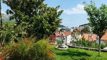 A residential area with a clear view of houses, a statue, and lush greenery.
