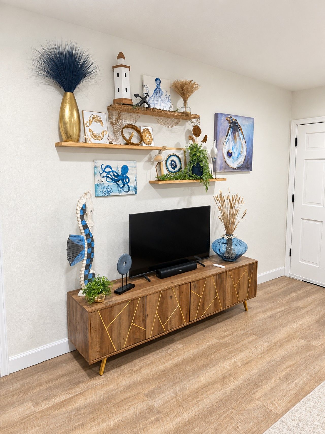 A modern living room with a wooden entertainment unit, a flat-screen TV, and various decorative items including artwork and plants.