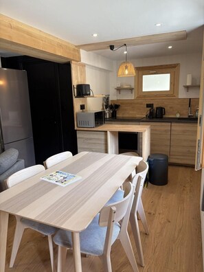 A compact kitchen with wooden cabinets, a built-in microwave, and a hanging light fixture. - 220m from ski slopes, Ground floor, terrace, tv, ski locker, 45m², Valloire (Valloire)
