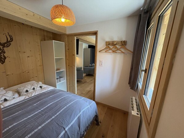 A bedroom with a bed, a hanging light fixture, a wardrobe, and a window. - 220m from ski slopes, Ground floor, terrace, tv, ski locker, 45m², Valloire (Valloire)